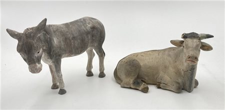 Lotto composto da due sculture da presepe raffiguranti bue e asino in materiali