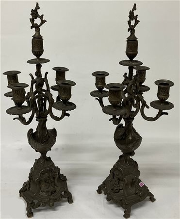 Coppia di candelabri in metallo a cinque fiamme con decori a motivi fogliacei e