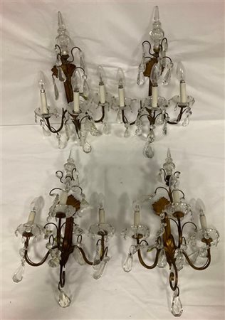 Gruppo di quattro applique a tre fiamme in metallo dorato decorate a volute fog