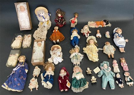 Cartone contenente numerose bambole e bamboline da collezione con volti ed arti
