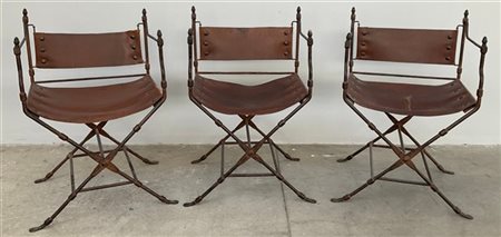 Gruppo di tre sedie da campo in ferro battuto con seduta e schienale in cuoio.