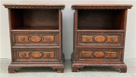 Coppia di comodini in legno intagliato con due cassetti, vano a giorno e piedi