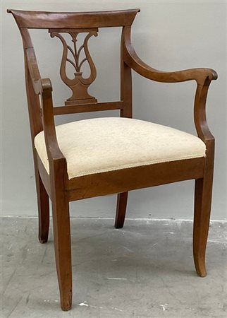 Poltrona di forma mossa in noce con schienale a giorno, cartella traforata a fo