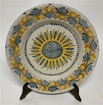  Antico piatto in maiolica decorata in policromia, falda a frutti e volute,