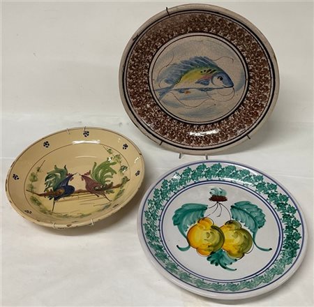 Lotto di tre piatti decorativi in terracotta smaltata e dipinta a frutti e anim