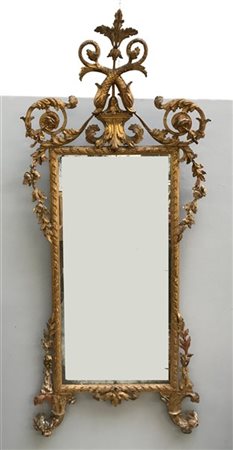 Specchiera in legno intagliato e dorato con decorazioni a volute e motivi veget