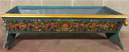 Culla in legno decorata a fondo azzurro intagliata in rilievo a fiori e teste d