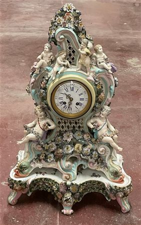 Pendola in porcellana con cassa riccamente decorata a motivi rocailles, ghirlan