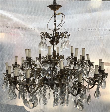 Lampadario in metallo dorato a ventiquattro bracci con pendenti e gocce in cris