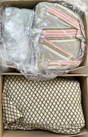Due cartoni contenenti un copriletto, cuscini, pizzi e altre stoffe di fatture