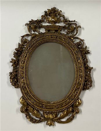 Piccola specchiera ovale con cornice in legno intagliato e dorato, secolo XIX (