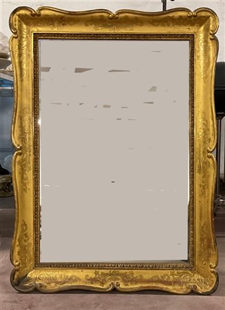 Specchiera con cornice a guantiera di forma sagomata in legno dorato e bulinato