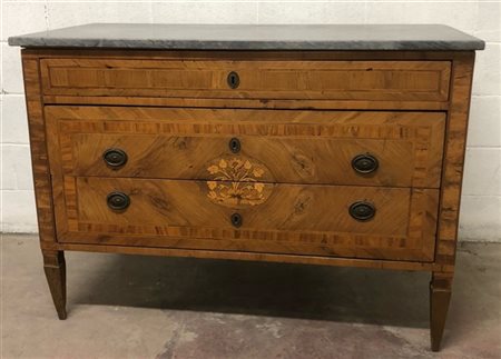 Cassettone lastronato, filettato e intarsiato in legni vari. Fronte a un casset