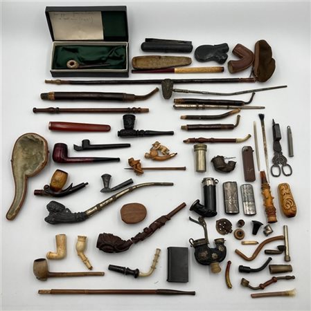 Cartone contenente parti di pipe e bocchini con decori e materiali differenti,