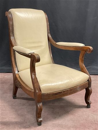 Poltrona di forma mossa in legno intagliato con rivestimenti in pelle. Secolo X