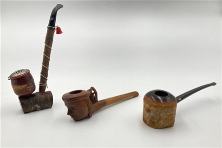 Lotto composto da tre pipe in legno e materiali differenti con decori stilizzat