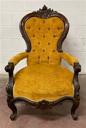 Poltrona in noce con cimasa intagliata a volute, gambe e braccioli sagomati. Se