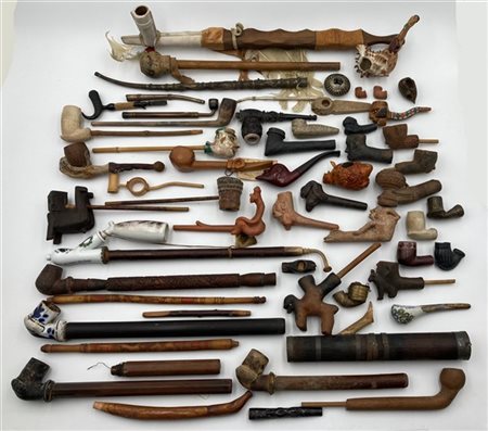 Cartone contenente parti di pipe e bocchini di epoche, decori e materiali diffe