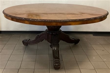 Tavolo da pranzo di forma tonda con piano lastronato e intagliato a motivi stil