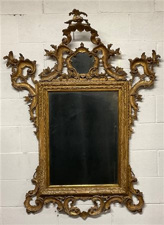 Antica specchiera in legno intagliato e dorato con cimasa a specchio e fregi sc