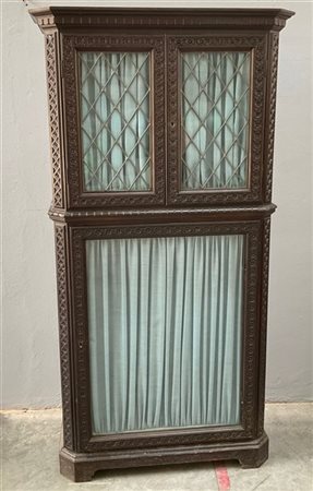 Libreria a due corpi in legno con fasce intagliate a fiori e motivi geometrici,