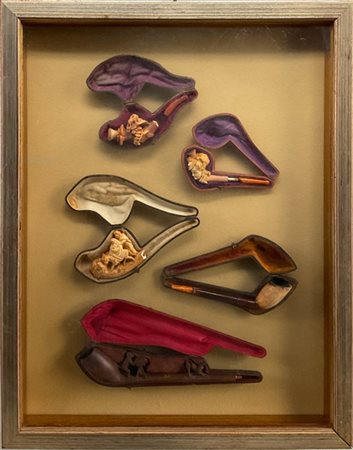 Lotto di due teche contenenti sette pipe in schiuma di mare ed altri materiali,