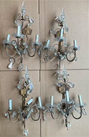 Gruppo di quattro applique a tre fiamme in metallo dorato decorate a volute fog