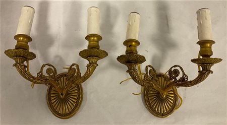 Coppia di applique a due fiamme in bronzo decorato e cesellato a volute e fiori