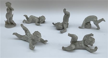 Gruppo di cinque amorini giocosi in porcellana bianca uniti ad un putto suonato