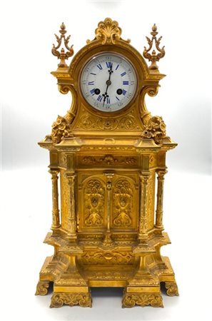 Pendola in bronzo dorato di forma architettonica riccamente decorata. Quadrante