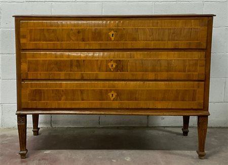 Comò con fronte a tre cassetti lastronato e filettato in legno chiaro. Gambe sc