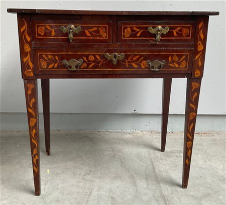 Tavolo da parete intarsiato in legni vari a volute e motivi fioriti. Un cassett