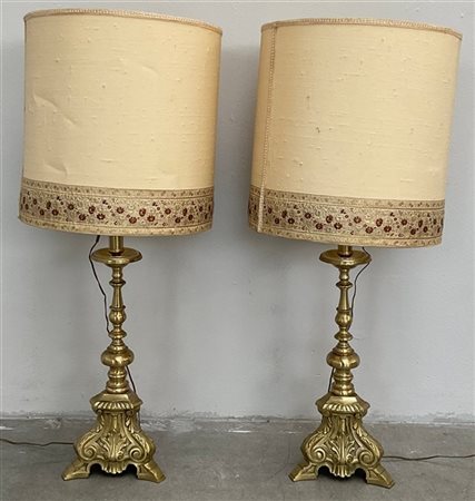 Coppia di candelieri tripodi in ottone a volute fogliate e riccioli (h. cm 43)