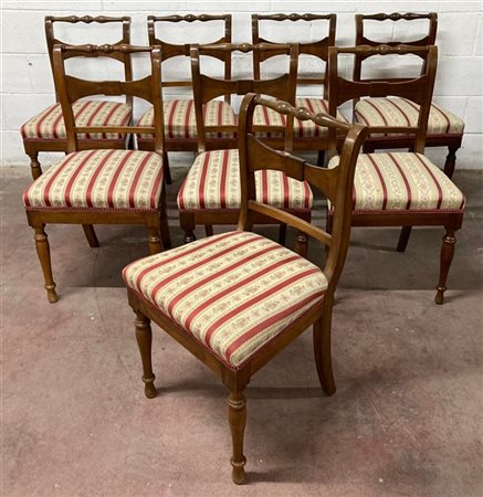 Gruppo di otto sedie in noce con schienale a giorno decorate a listelli, gambe