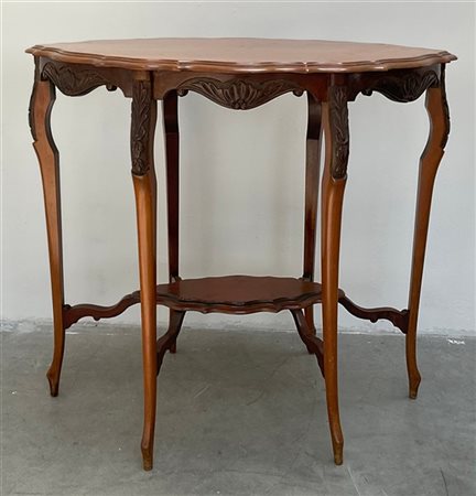 Tavolino in noce di forma sagomata intagliato a foglie, riccioli e valve di con