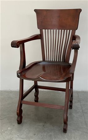 Poltrona con schienale decorato a listelli. Braccioli a ricciolo e gambe sagoma