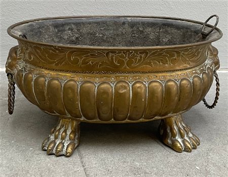 Fioriera biansata in rame sbalzato, anse a teste leonine e piedi a zampa ferina