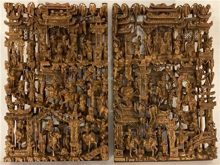 Coppia di pannelli in legno finemente intagliato e dorato, decorati con scene d