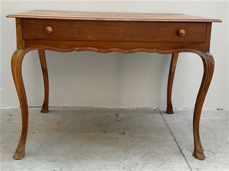 Tavolo in legno intagliato, cassetto nella fascia, gambe mosse terminanti a zam