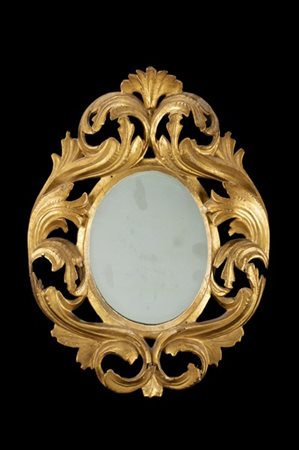 Specchiera ovale con cornice traforata in legno intagliato e dorato decorato a