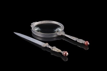 Lente da tavolo in argento con presa decorata a volute, mascheroni floreali e v