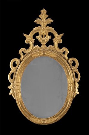 Specchiera ovale con cornice in legno intagliato e dorato, decorata a volute fo