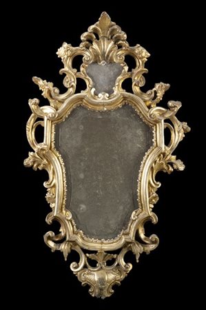 Specchiera di forma sagomata in legno intagliato, dorato e traforato a fiori e