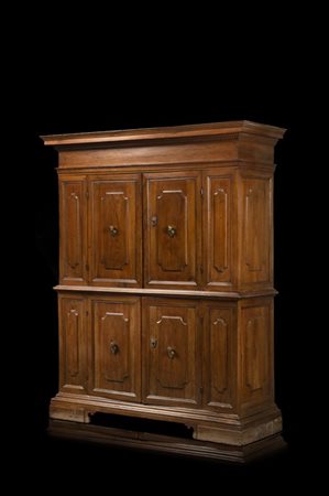 Canonica in noce con fronte a quattro ante pannellate, prese a teste muliebri i