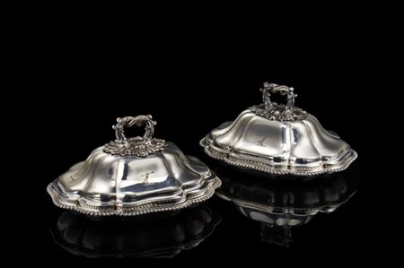 Coppia di legumiere di forma mossa in argento sbalzato. Prese ad anello decorat