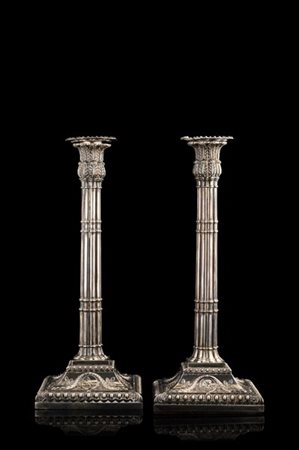 Coppia di candelieri in argento con fusto decorato ad elementi stilizzati. Base