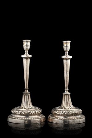 Coppia di candelieri a colonna in argento con basi e bobeche decorate a foglie