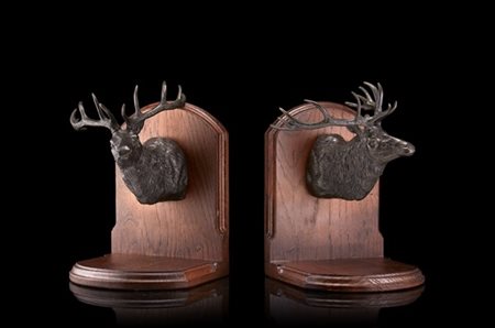 Coppia di fermalibri in legno intagliato decorati da renne in metallo a tutto t