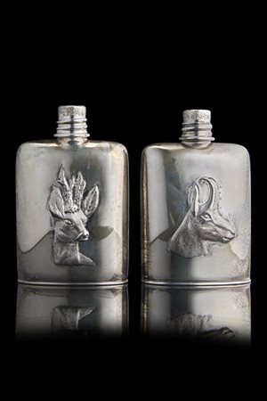 Due fiaschette in argento decorate con cervo e camoscio in rilievo. Titolo 800.