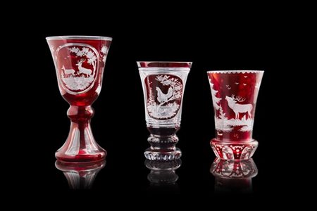 Manifattura di Boemia, fine secolo XIX. Gruppo di tre calici in vetro rosso inc